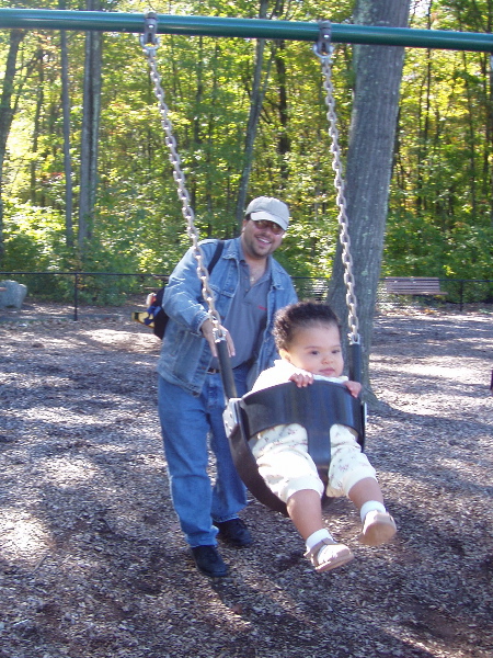 Daddy pushes Kayla in a Swing